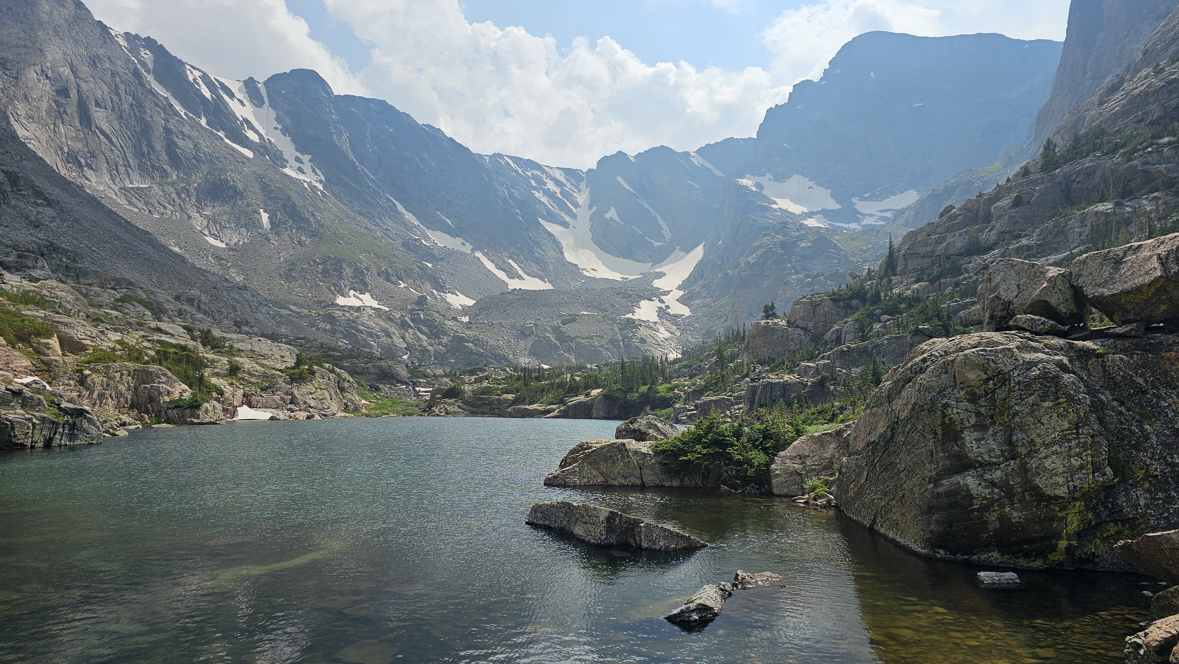 Sky Pond cirque glow — glassy water, spires, and first light.