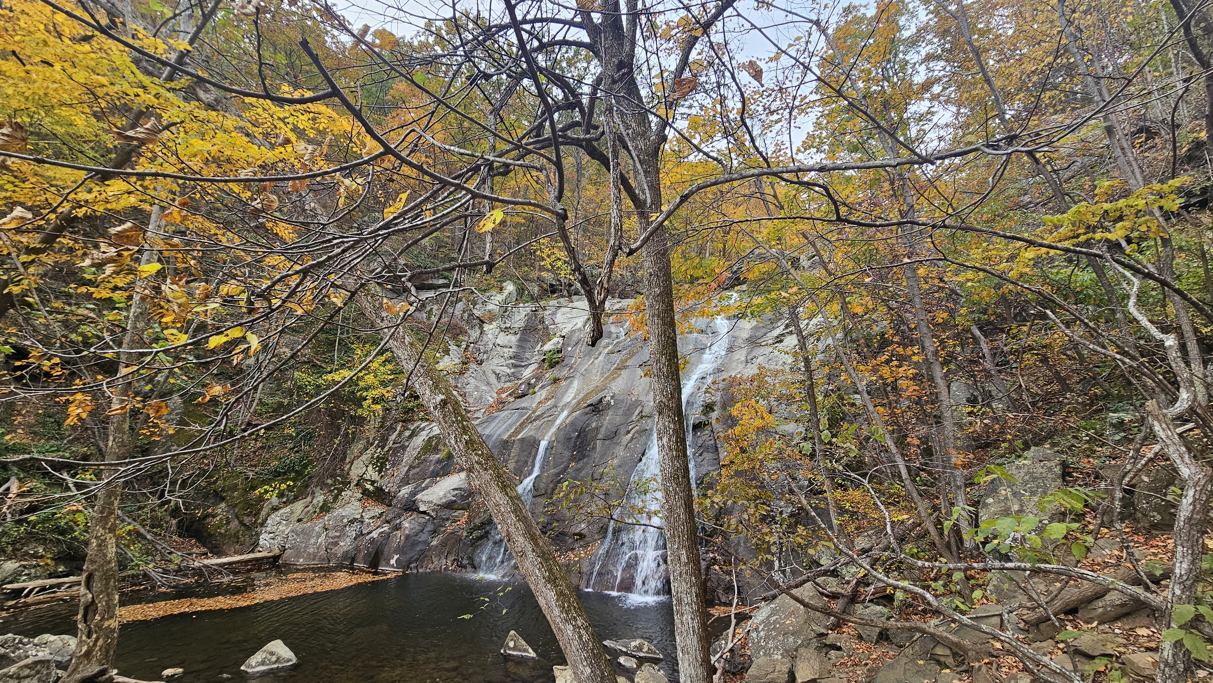 Whiteoak Canyon waterfall surrounded by colorful autumn foliage in Shenandoah National Park